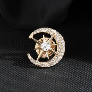 Eleganter goldener Himmelsbrosche mit Sichelmond und Stern auf schwarzem Stoff
