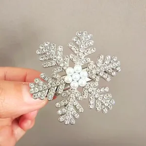 Close-up of snowflake hair clip with shiny rhinestones and white pearl center details