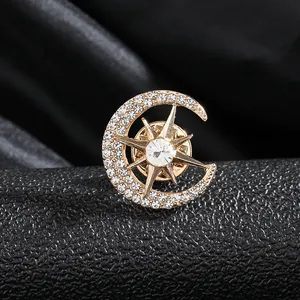 Eleganter Stern- und Mond-Brosche in Gold mit funkelnden Strasssteinen auf schwarzem Leder
