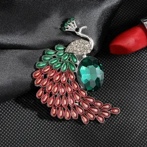 Detalle de broche de pavo real con gema verde y plumas de esmalte sobre tela oscura