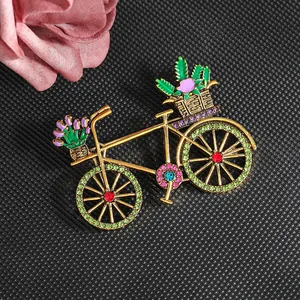 Vintage gold bicycle brooch with colorful floral rhinestones on a black texture base