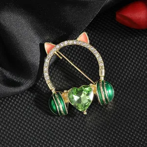 Cat ear headphone brooch with green heart crystal and rhinestones on black fabric