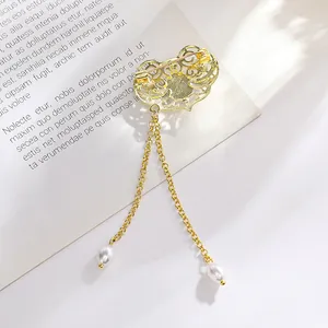 Broche vintage dorado con borlas de perlas y detalles de diseño de estilo chino antiguo