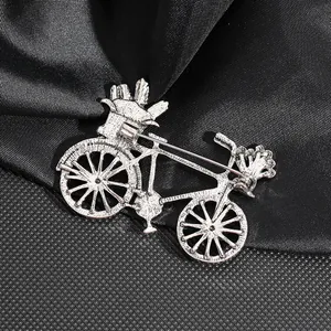 Vintage silver metal bicycle brooch showing detailed back view on black textured fabric