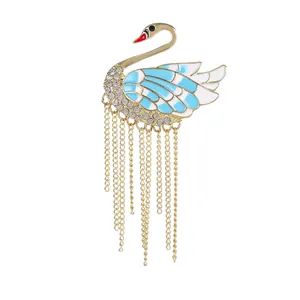 Elegant swan brooch with blue enamel wings, sparkling rhinestones and gold tassel chains