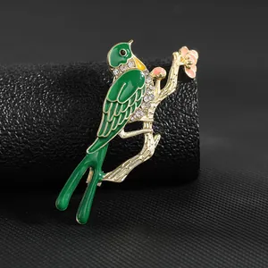 Detalle de un broche de fénix esmaltado con cristales en una rama dorada elegante