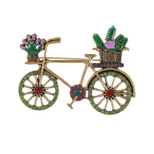 Vintage green bicycle brooch pin with colorful rhinestones and floral details on white background
