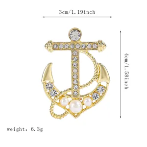 Detail view of gold anchor brooch with sparkling rhinestones, pearls and rope texture