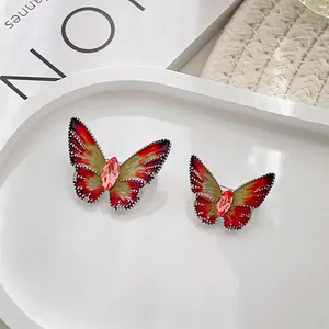 Detail of butterfly brooches with red and yellow gradient oil dripping and pink crystals