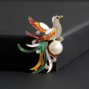 Primer plano de un broche de fénix con esmalte multicolor y cristales brillantes