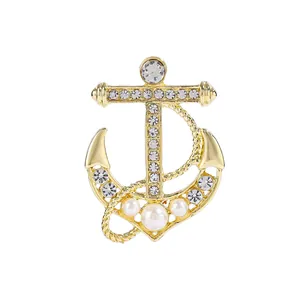 Sparkling anchor brooch with crystals and pearls on polished gold-plated metal base