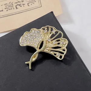 Élégante broche en feuille de ginkgo dorée avec cristaux sur boîte cadeau grise