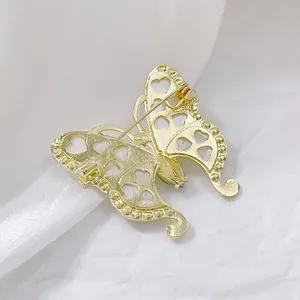 Rückansicht einer goldenen Schmetterlingsbrosche mit Herz-Ausschnitten und Verschluss