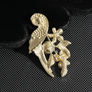 Detalle posterior del broche de fénix dorado que muestra el cierre y la textura del metal