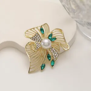Elegant emerald marquise and pearl floral brooch in gold finish with white rhinestones