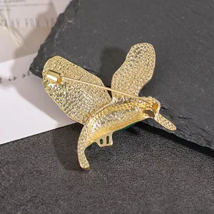 Vue arrière de la broche colibri montrant la texture dorée et le fermoir de sécurité