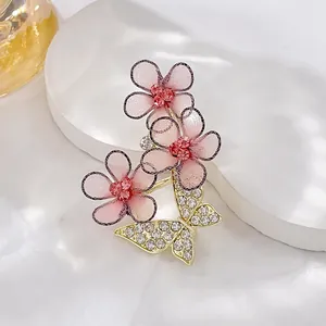 Detailed macro of flower brooch with pink rhinestones and a crystal-encrusted butterfly