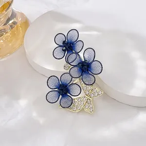 Detail of elegant blue mesh flower brooch with sparkling rhinestone butterfly pin