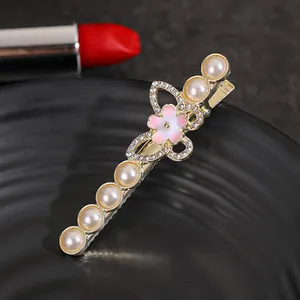 Pince à cheveux dorée avec perles, fleur dégradée et papillons en strass
