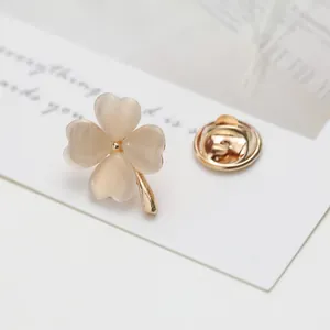 Macro shot of clover lapel pin with cat-eye heart petals and a gold metal base