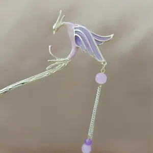 Detail of silver phoenix hair pin with purple enamel wings and elegant hanging tassels