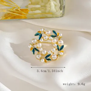 Detalle de broche floral redondo con hojas verdes y perlas, tamaño 3,4 cm en seda