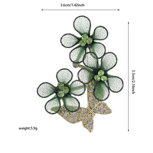 Detailed view showing dimensions of flower and butterfly brooch with green rhinestones