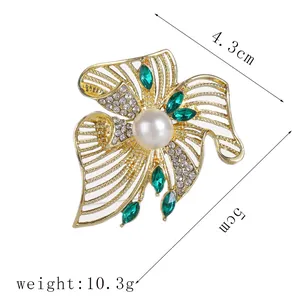 Detailed size view of flower brooch with emerald stones and pearl, 4.3cm by 5cm size