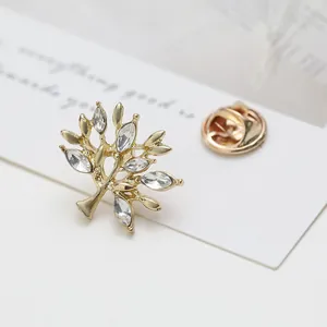 Detailed macro view of a golden tree-shaped brooch with marquise-cut crystals and pin back