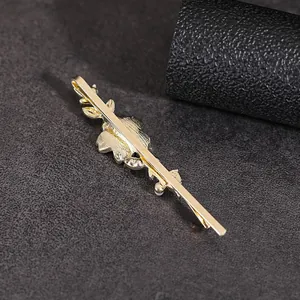 Golden floral metal hair clip with layered leaf design shown from side and back view