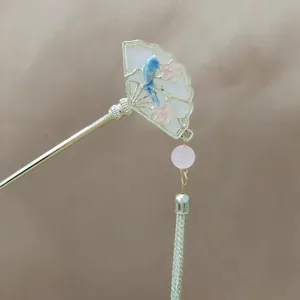 Detail of silver hair stick with blue fan-shaped flower pattern and pink beaded tassels