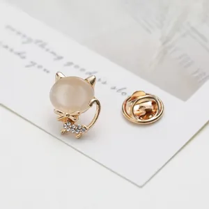 Close-up of golden cat brooch with opal stone and sparkling rhinestones on card