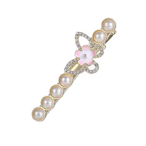 Barrette dorée style Saturne ornée de perles, d'une fleur rose et de cristaux étincelants