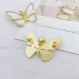 Elegant butterfly brooch with white enamel, pearls and crystals shown from two angles