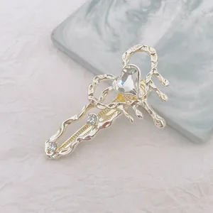 Detalle de una pinza para el pelo plateada estilo lava con gema en forma de corazón