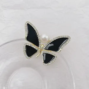 Elegant black enamel butterfly brooch with gold plating, sparkling crystals and white pearl