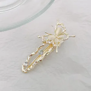 Detalle de pinza para el pelo de mariposa dorada con alas de piedra de luna y brillo