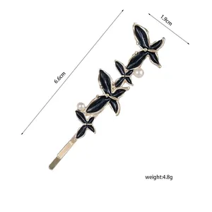 Detailansicht der Haarspange mit Schmetterling aus Goldmetall, Emaille und Perlen