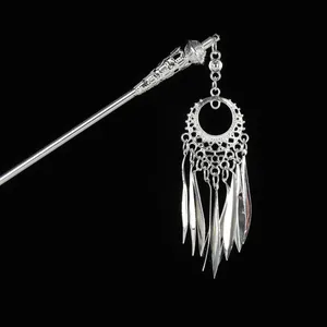 Detailed close-up of hollowed silver hair stick with elegant metal tassel pendants