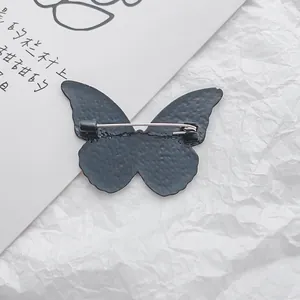 Matte black butterfly brooch with hammered texture and secure silver pin backing