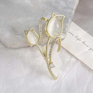 Elegant gold tulip brooch with opal cat eye stones and sparkling crystal accents