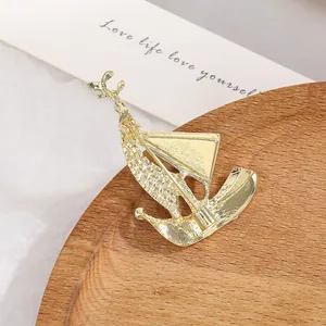 Elegant gold sailboat brooch for suits featuring a secure pin clasp and metal finish