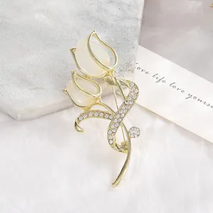 Macro shot of tulip brooch with opal petals and rhinestones on marble background