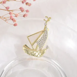 Macro shot of golden sailboat brooch with shimmering white rhinestones and mesh texture