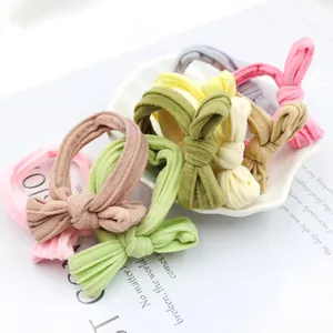 Bow hair ties set in assorted pastel colors made of ribbed elastic fabric on a plate