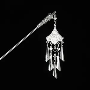 Close-up of vintage silver hair pin featuring hollowed craftsmanship and long tassel charms