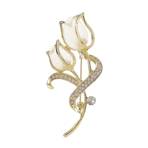 Elegant gold tulip brooch with opal petals and crystal rhinestones on a white background