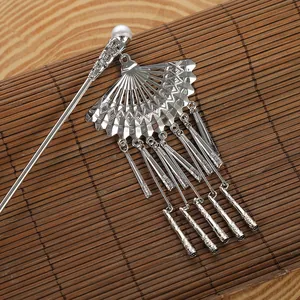 Pic à cheveux chinois avec pendentif éventail et glands argentés sur tapis en bambou