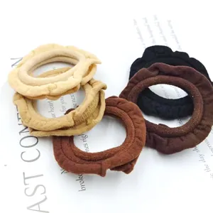 Elastic ruffled fabric hair scrunchies in various earth tones like black and brown