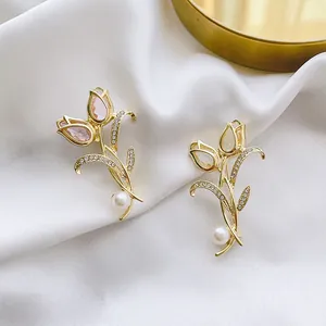 Élégante broche tulipe avec zircons et perle sur fond de satin blanc soyeux